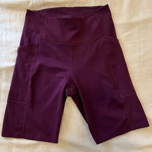 Girlfriend Collective plum bike shorts with pockets.
